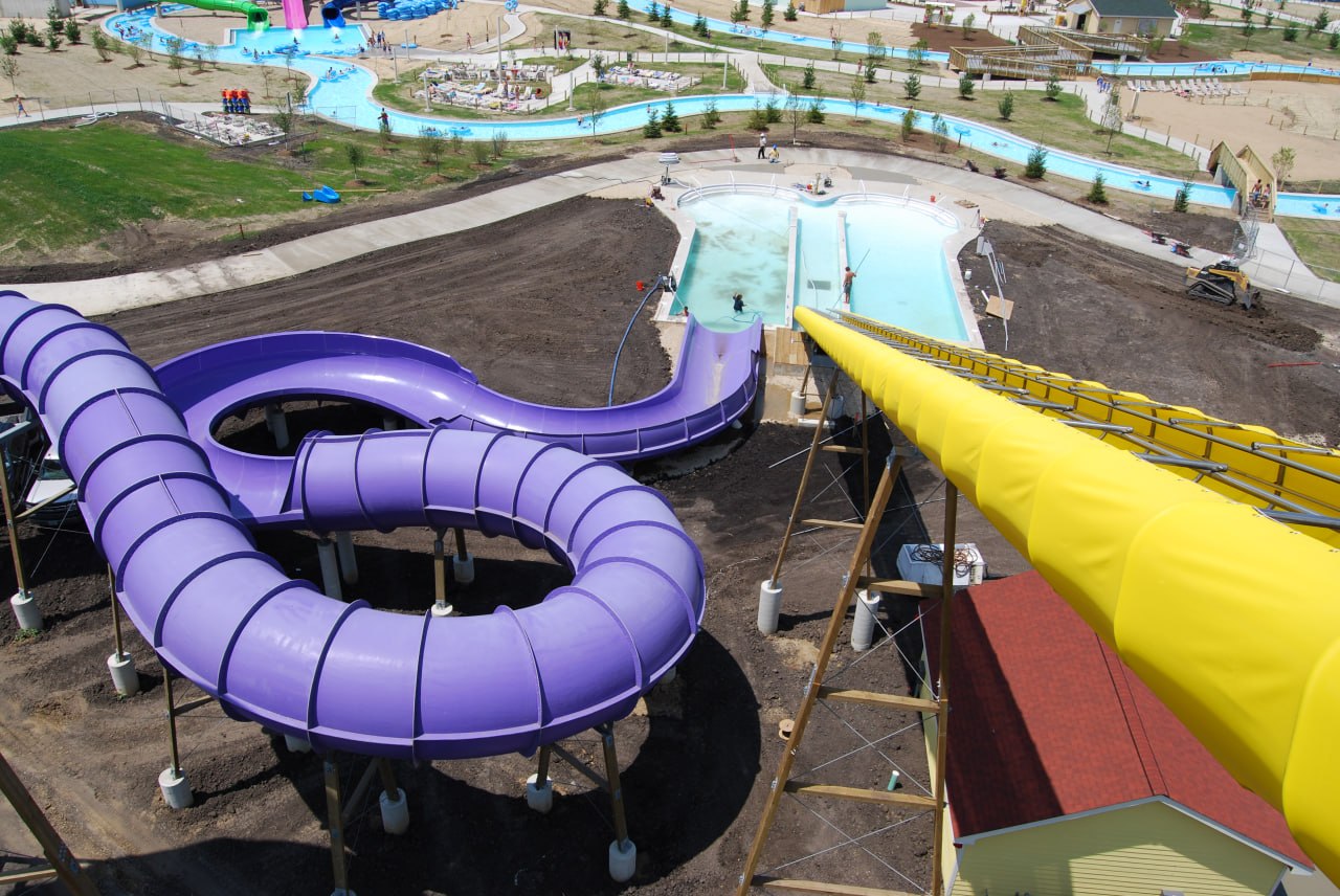 Aerial view of a newly constructed water park with purple and yellow slides