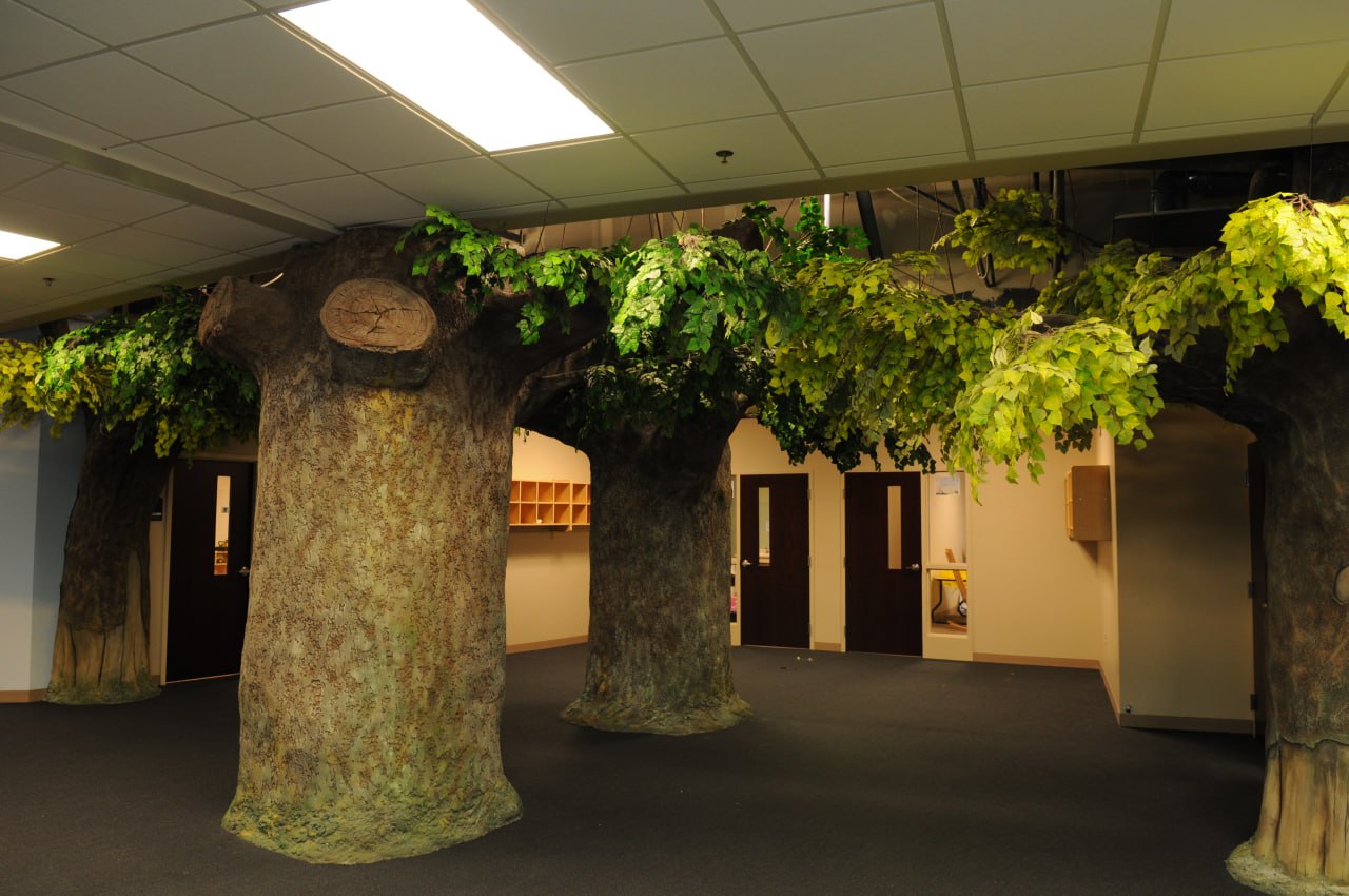Office space with large artificial tree sculptures and nature-inspired design