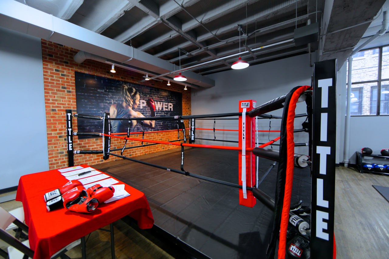 Boxing training facility with ring and branded mural